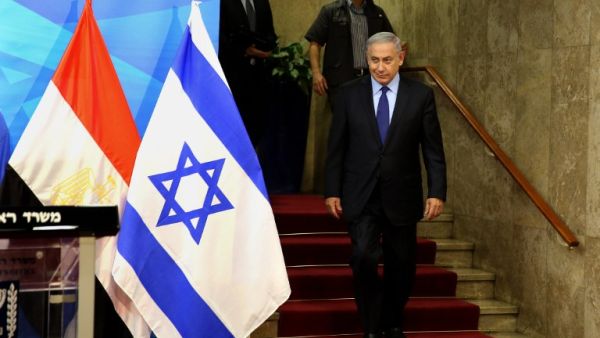 Israeli Prime Minister Benjamin Netanyahu walks to welcome the Egyptian foreign minister prior to their meeting at his Jerusalem office on July 10, 2016. (AFP/Gali Tibbon)