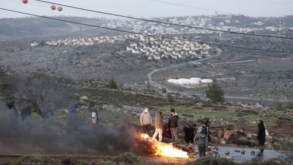 Jewish settlers set tyres ablaze at the Amona outpost, northeast of Ramallah, on February 1, 2017 as Israeli security forces are preparing to evict the hardline occupants of the wildcat settlement outpost. (AFP/Jack Guez)