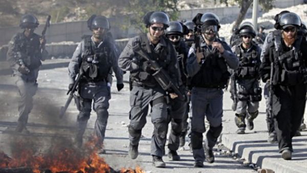 Israeli security officers run past burning tires during clashes with Palestinian protesters in the Issawiya district of Arab east Jerusalem on October 24, 2014. (AFP/ Ahmad Gharabli) 
