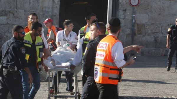 Israeli medics carry an injured man following a Palestinian stabbing attack near the Herod's Gate entrance to the Old City of Jerusalem. (Menahem Kahana/AFP)