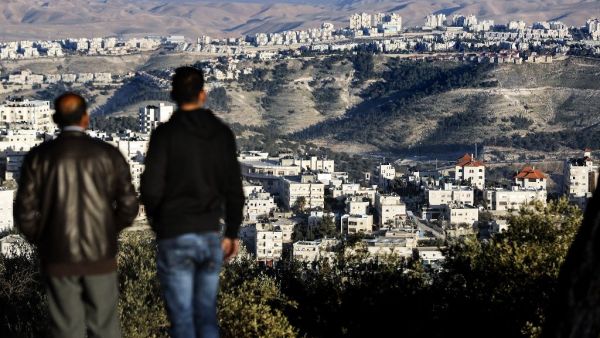 Two men observe the Israeli settlement of Maale Adumim in the Palestinian West Bank from Jerusalem on January 23, 2017. (AFP/Thomas Coex)