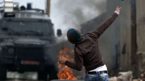 A Palestinian protester throws a stone towards Israeli security forces during clashes following a weekly demonstration against the expropriation of Palestinian land by Israel in the village of Kfar Qaddum, near Nablus, in the occupied West Bank on March 17, 2017. (AFP/Jaafar Ashtiyeh)