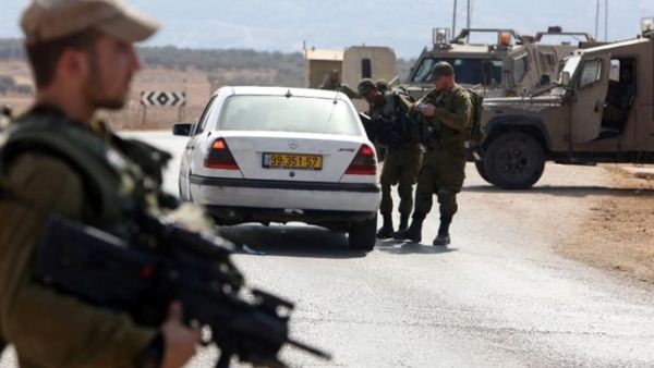 Israeli soldiers examine a car at a checkpoint east of Nablus. (AFP/File)