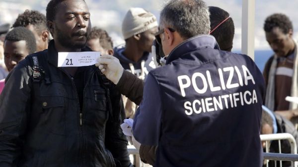 A migrant is logged as he disembarks from a Maltese coast guard patrol vessel after being rescued at sea, on April 15, 2016, at the Messina harbor in Sicily. (AFP/Giovanni Isolino)