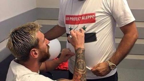 Leo Messi (Left) signs a Syrian fan's T-shirt. (Twitter)