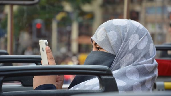 Woman in niqab snaps a photo with her phone