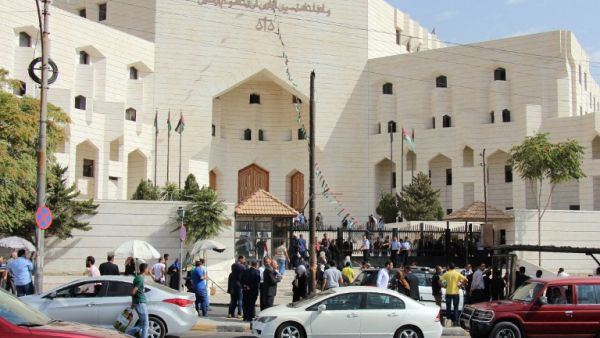 Police and civilians gather outside the court in Amman's Abdali neighborhood, where cartoonist Nahed Hattar was shot and killed. (AFP/Ahmad Alameen)