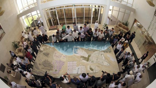 A picture taken with a fish-eye lens shows Chinese investors listening to an explanation as they check the model of the dry dock which is to be built following an economic agreement, on May 24, 2016 in the Omani port city of Duqm. Mohammed Mahjoub /AFP Photo