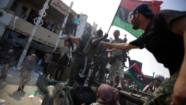 مقاتلو المجلس الإنتقالي لحظة دخولهم باب العزيزية في العاصمة طرابلس