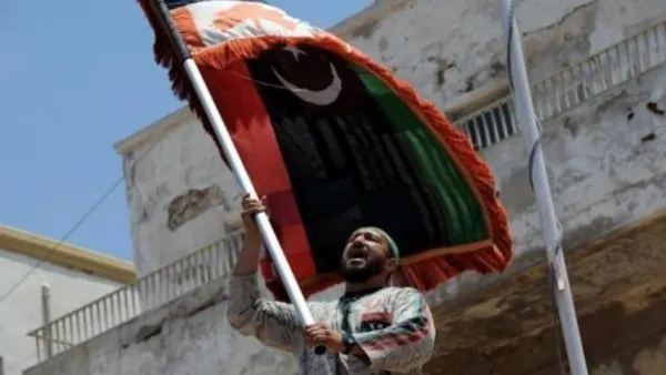 ليبي يلوح بعلم الثورة خلال تظاهرة في بنغازي بعد صلاة الجمعة

