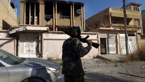 A fighter loyal to Libya's internationally recognized government walks along damaged a street in Benghazi after seizing the center of the city on Feb. 23, 2016 from Daesh militants. (AFP/Abdullah Doma)
