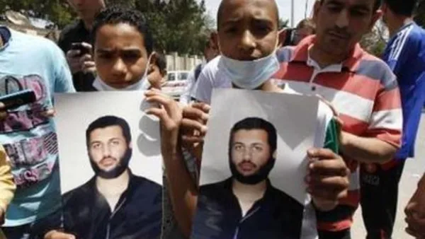 شابان يحملان صورة لسيف العرب القذافي في طرابلس يوم الاحد.
