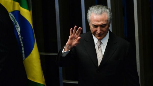 President Michel Temer waves as he takes office before the plenary of the Brazilian Senate in Brasilia, on August 31, 2016. (AFP/Andressa Anholete)