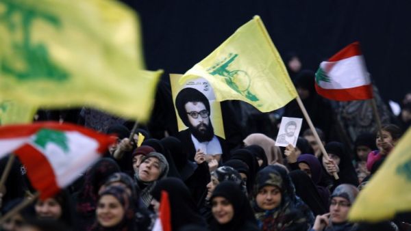 Supporters wave the flag of Lebanon's Shiite movement Hezbollah during a rally held in the southern suburbs of Beirut on February 16, 2016. (AFP/Anwar Amro)