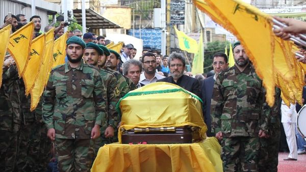 Adnan (C-L) and Hassan Badreddine (C-R), brothers of slain top Hezbollah commander Mustafa Badreddine who was killed in an attack in Syria, mourn next to his casket during the funeral in the Ghobeiry neighborhood of southern Beirut on May 13, 2016. (AFP/Anwar Amro)