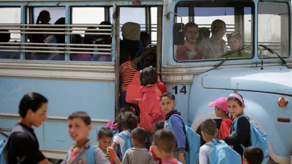 Syrian refugee children prepare to board a school bus at an unofficial refugee camp in Lebanon's town of Bar Elias in the Bekaa Valley on May 13, 2016. (AFP/Joseph Eid)
