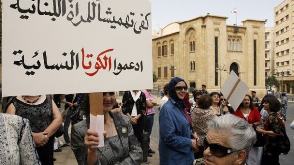 An activist carries a banner that reads 'Enough marginalisation of Lebanese women, support the feminine quota" during a sit-in outside the Lebanese parliament in downtown Beirut. (AFP/ File Photo)
