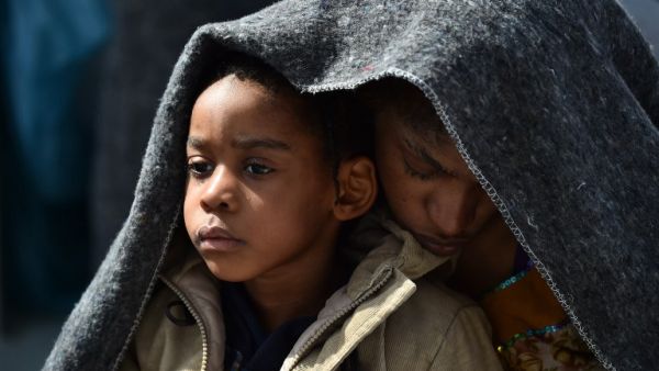 A woman and her daughter protect themselves with a blanket aboard the rescue ship "Aquarius", on May 25, 2016 a day after a rescue operation of migrants and refugees off the Libyan coast. (AFP/Gabriel Buoys)