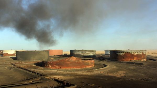 This file photo taken on January 08, 2016 shows smoke billowing from a petroleum storage tank after a fire was extinguished at Al-Sidra oil terminal, near Ras Lanuf, in the so-called "oil crescent" along Libya's northern coast. (AFP/Stringer This file photo taken on January 08, 2016 shows smoke billowing from a petroleum storage tank after a fire was extinguished at Al-Sidra oil terminal, near Ras Lanuf, in the so-called "oil crescent" along Libya's northern coast. (AFP/Stringer