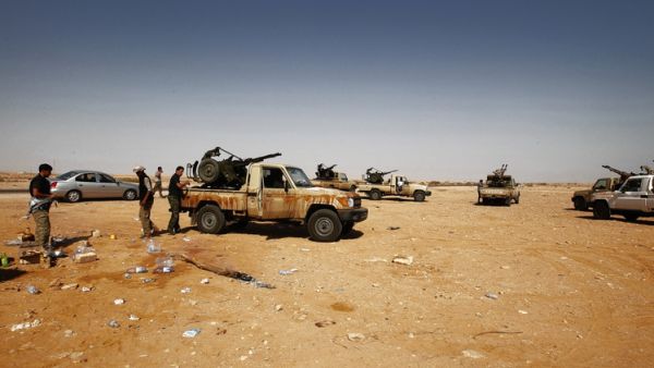 Militiamen serving Ibrahim al-Jathran (below) outside a Libya oil terminal after shutting it down in July. (AFP/ File)