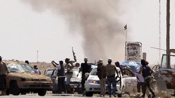 Libyan National Transitional Council fighters come under Grad missiles attack from Gaddafi loyalists at an outpost on the outskirts of the city of Bani Walid. (Joseph Eid/ AFP)