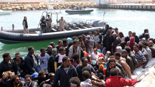The Libyan coast guard watches over a group of African migrants after towing their boat to the Tripoli shore. (AFP/File)
