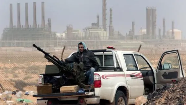 Libyan rebels sit with an anti aircraft weapon in front of an oil refinery. (AFP/File)
