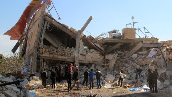 People gather outside the ruins of the MSF hospital in the Idlib province. (AFP/Ghaith Omran)