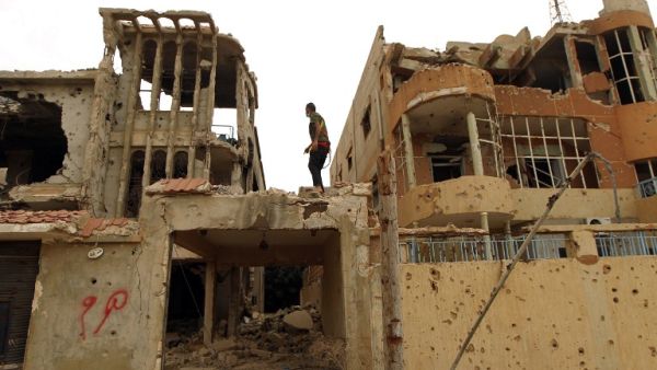 A man stands atop a gutted building in Benghazi, Libya, where many Daesh attacks have occurred in recent months. (AFP/Abdullah Doma)