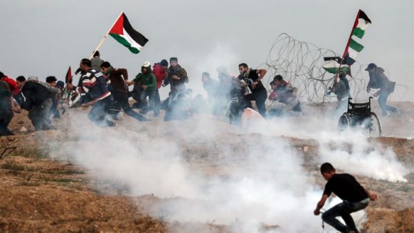 Palestinian demonstrators run for cover during a protest on November 16, 2018, on the eastern outskirts of Gaza City, near the border with Israel. (MAHMUD HAMS / AFP)
