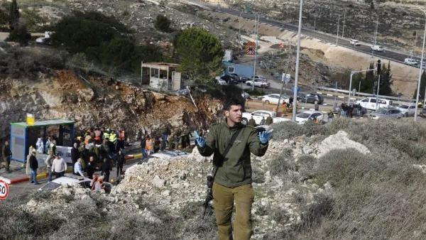 Israeli forces and forensic experts inspect the site of a Palestinian drive-by shooting attack outside the West Bank settlement of Givat Asaf, northeast of Ramallah, on December 13, 2018. (AFP)