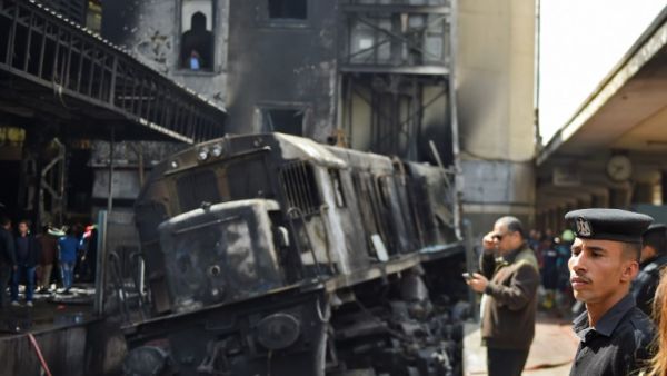 Members of the security forces and onlookers gather at the scene of a fiery train crash at the Egyptian capital Cairo's main railway station on February 27, 2019. (AFP/ Mohamed el-Shahed)