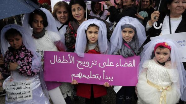 Young Lebanese girls disguised as brides hold a placard as they participate in a march against marriage before the age of 18, in the capital Beirut on March 2, 2019. (ANWAR AMRO / AFP) 