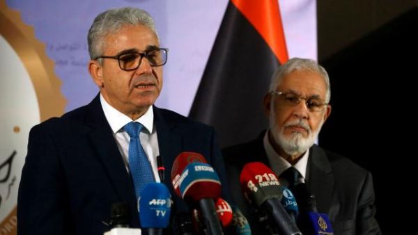 Libyan Foreign Minister Mohamed Taher Siala (R) and Interior Minister Fathi Bash Agha (L) deliver a speech following an attack on the Foreign ministry. (AFP)