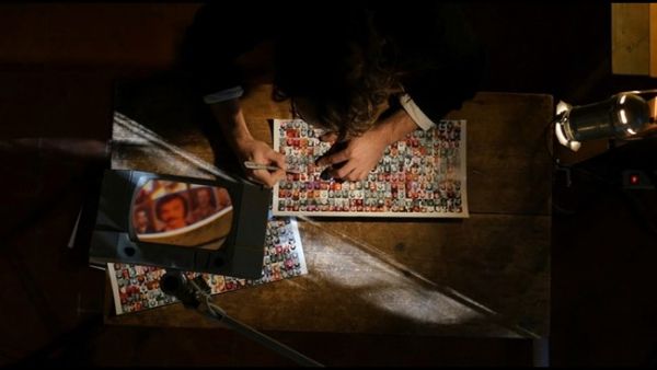 Halwani removes the portrait of a missing person from a collection of such portraits, "Erased, __ ascent of the invisible." (Photos courtesy of TIFF)