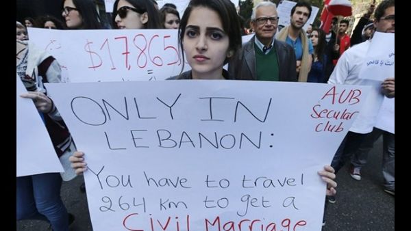 Lebanese protestors hold placards during a demonstration against the ongoing ban on civil unions in the Lebanese capital Beirut on March 1, 2015. (AFP)