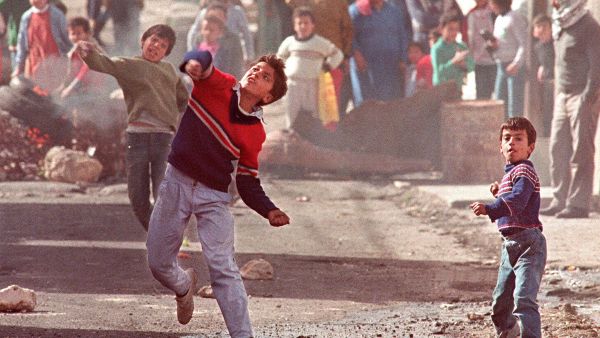 Palestinians throw stones in Ramallah as part of the 1st 1987 Intifada. (AFP)