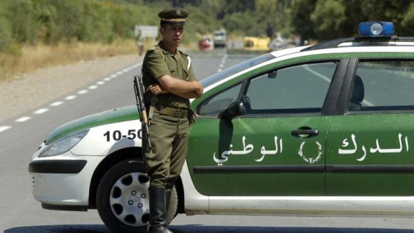 An Algerian policeman stands guard as security forces block the road to Lakhdaria. (AFP Photo/Fethi Belaid)
