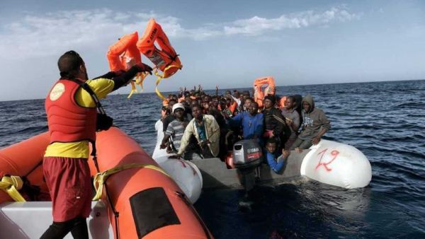 A member of Spanish humanitarian NGO Proactiva Open Arms, throws life jackets to refugees and migrants during a rescue operation off the coast of Libya on October 3, 2016. (AFP / Aris Messinis)