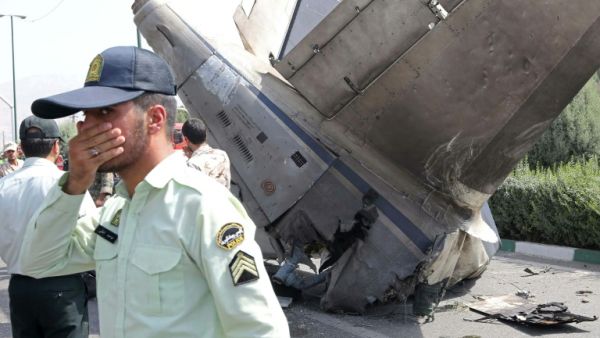 Iranian security forces stand at the scene of a previous plane crash near Tehran's Mehrabad airport on August 10, 2014. (AFP/ File)