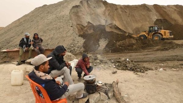 Unemployed Tunisians sit at a phosphate production plant in Kef Eddour. (AFP)