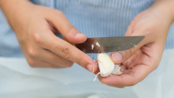 ضعي رأس الثوم على الطاولة واضغطي عليه براحة يدك بقوّة.
