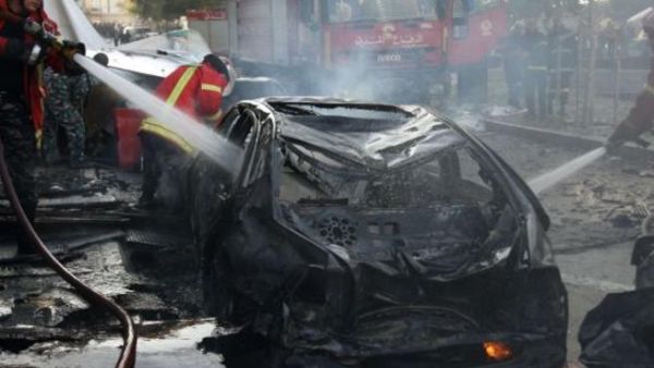Lebanese douse a burring vehicle set ablaze by a massive car bomb explosion that rocked central Beirut on December 27, 2013. [AFP]