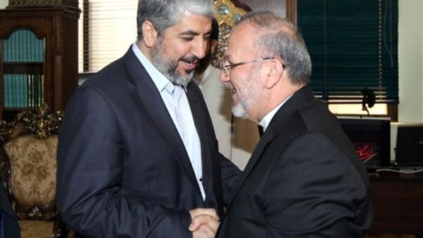 متقي يصافح زعيم حركة حماس، خالد مشعل، خلال زيارته الى دمشق مطلع الشهر/أ.ف.ب