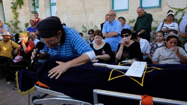 Israeli Rina Yaffa Ariel, mourns over the body of her daughter Hallel, a 13-year-old girl who was fatally stabbed by a Palestinian attacker in her home, during her funeral in the Kiryat Arba settlement on June 30, 2016. (AFP/Gil Choen-Magen)