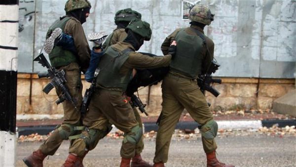 Israeli soldiers carry a Palestinian after he was detained during clashes in the West Bank city of Bethlehem on November 6, 2015. (AFP/File)