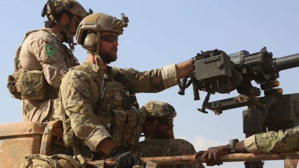US soldiers, one apparently wearing the badge of the YPG, in Fatisah, Raqqa province, on 25 May 2016. (AFP/File)