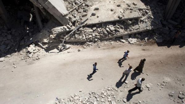 Syrians walk past destroyed buildings in Al-Bab in the northern province of Aleppo on 1 September 2012. (AFP/Achilleas Zavallis)