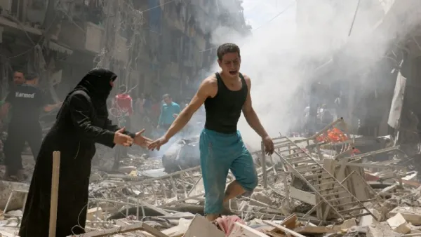 People walk amid the rubble of destroyed buildings following a reported air strike on the rebel-held area of Aleppo. (AFP/File)