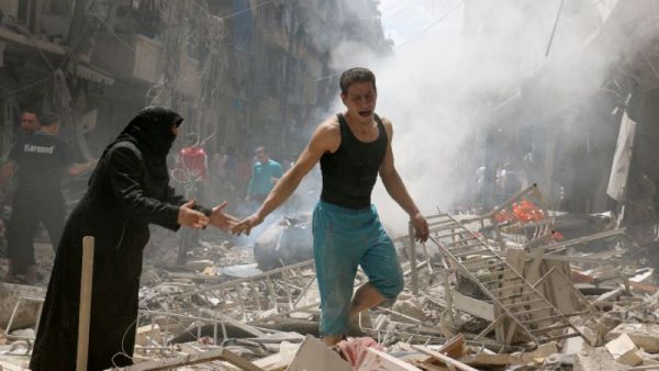 People walk amid the rubble of destroyed buildings following a reported air strike on the rebel-held neighbourhood of al-Kalasa in Aleppo, Syria on April 28, 2016. (AFP/Ameer Alhalbi)